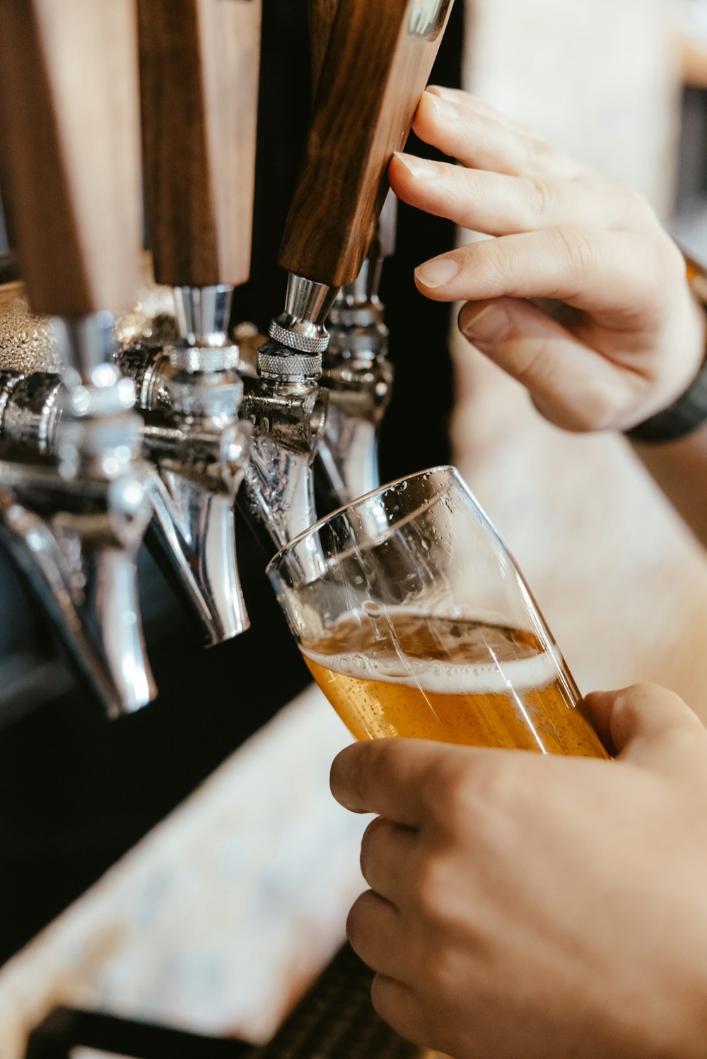 Ein Bier wird am Zapfhahn eingeschenkt